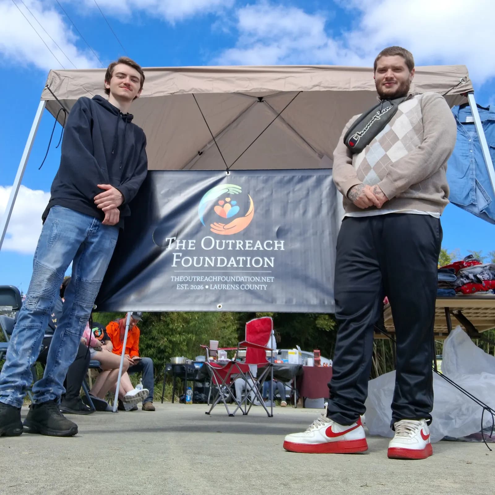 Visitors by The Outreach Foundation banner at the coat drive