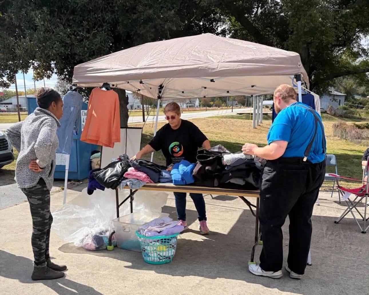 Joyce Stephens going through coats with a neighbor and a volunteer