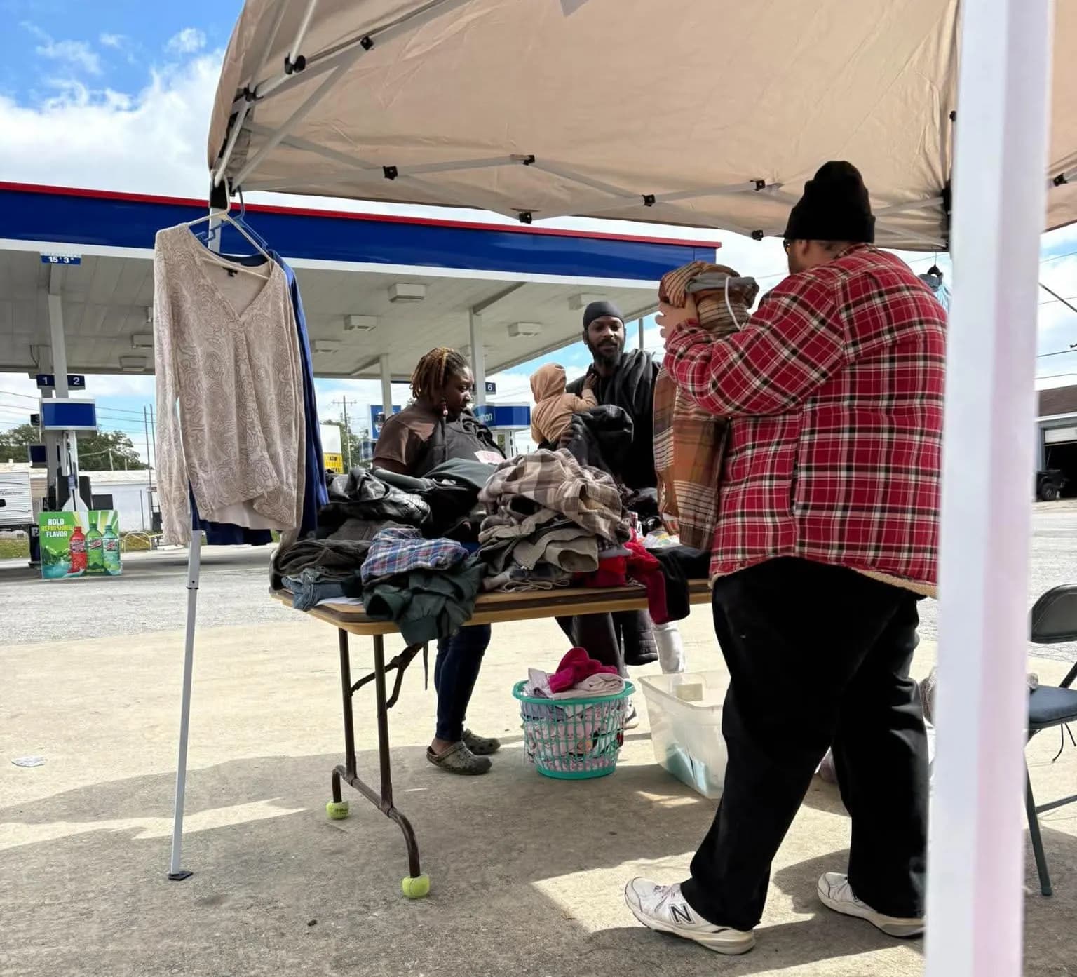 A volunteer shows a coat to a family who stopped by the giveaway